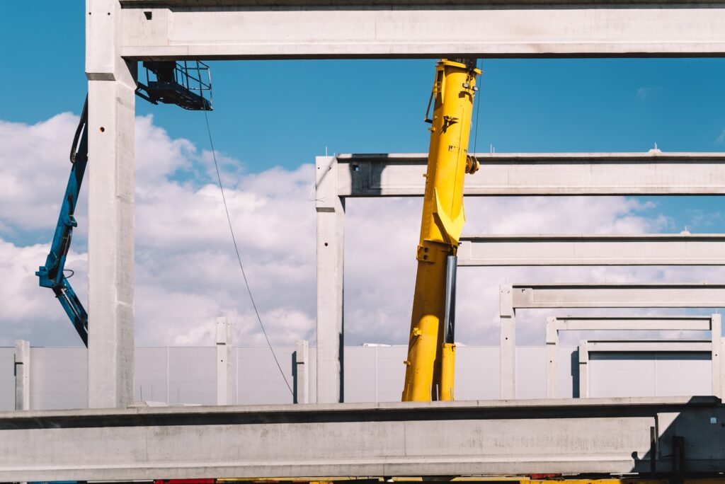 Industrial crane lifting concrete beams, prefabricated cement beams
