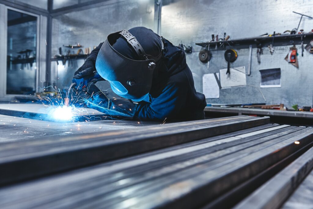 Master the Weld. Industrial steel welder in factory